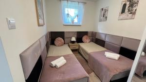 a small room with two beds and a window at Mały cichy zakątek in Ciechocinek