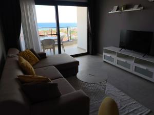 a living room with a couch and a flat screen tv at Caesar Blue Resort & Spa apartment I-66 in Kalecik