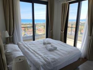 a bed in a hotel room with a large window at Caesar Blue Resort & Spa apartment I-66 in Kalecik