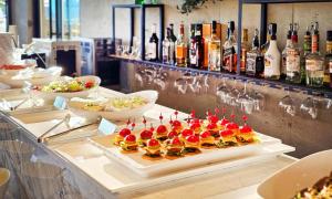 a buffet with a tray of appetizers and bottles of wine at 대구 이스턴호텔 라이온즈파크점 in Daegu