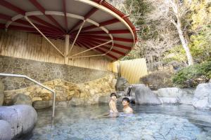 two children are sitting in a pool of water at Ooedo Onsen Monogatari Gero Bekkan in Gero