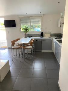 a kitchen with a table and some chairs in it at Villa kaja in Saint-Porchaire