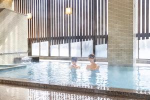 a woman and a child in a swimming pool at Ooedo Onsen Monogatari Gero Bekkan in Gero +43 photos