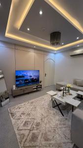 a living room with a large flat screen tv at شقق مرفا in Hail