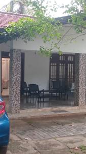 a porch of a house with chairs and tables at The banglow homestay in Anuradhapura +4 photos