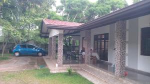 a house with a car parked in front of it at The banglow homestay in Anuradhapura