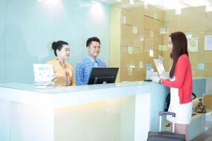 a woman is standing at a counter in a store at Inn86 in Bintulu