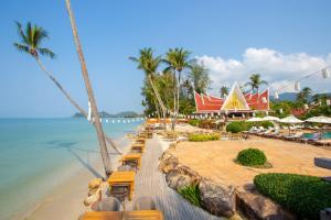 ein Strand mit Liegestühlen, ein Restaurant und das Meer in der Unterkunft Santhiya Koh Chang Resort - Up to THB 3,000 Resort Credit per Night in Ko Chang