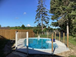 a fence around a swimming pool with a net around it at Chambre du merle in Illats