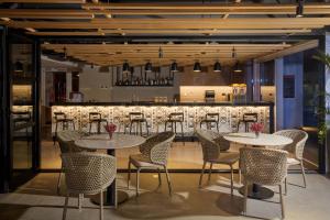 a restaurant with tables and chairs and a bar at Radisson RED Cebu Mandaue in Cebu City