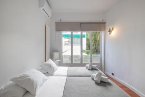 a white bedroom with a large bed and a window at Villa Cela in El Masnou +31 photos