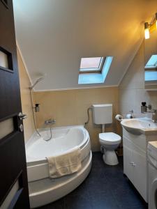 a bathroom with a tub and a toilet and a sink at Cozy Corner Apartments in Bistriţa +49 photos