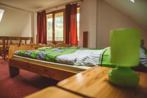 1 dormitorio con cama y mesa de madera en Penzion U Černého Potoka, en Nová Lhota