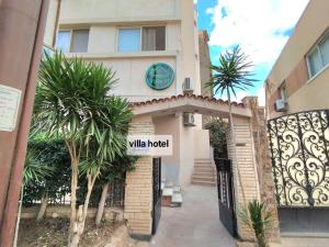 a building with a gate and palm trees in front of it at new Villa117 in Cairo