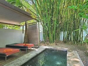 a pool of water with a bed next to a garden at Native Lodge et Spa in Mahébourg +10 photos