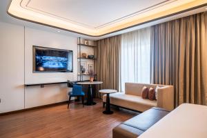 a hotel room with a couch and a table at Radisson Blu Hotel Ahmedabad in Ahmedabad