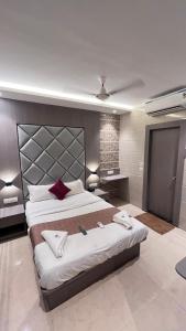 a large bedroom with a large bed with red pillows at Hotel Abrol in Mumbai +3 photos