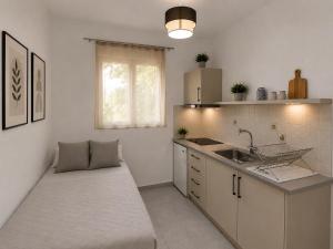 a kitchen with a couch in the middle of it at Oceanica k rooms in Loutsa +17 photos