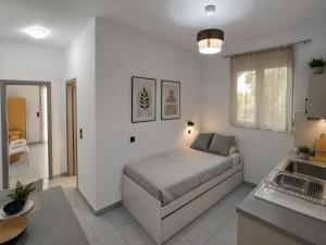 a bedroom with a bed in a white room at Oceanica k rooms in Loutsa