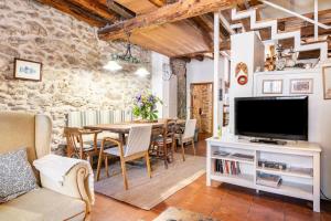a living room with a table and a tv at Casa Valle del Lozoya in Rascafría