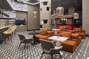 a lobby with a couch and tables and chairs at Radisson RED Cebu Mandaue in Cebu City