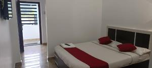 a bedroom with a bed with red pillows on it at Bluebell Holiday Inn in Yercaud