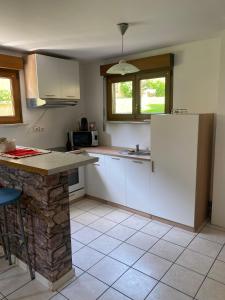 a kitchen with white cabinets and a counter top at Côté Jardin in Bourgheim