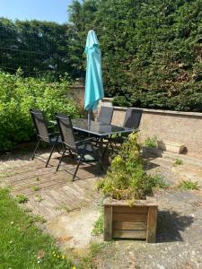 a table and chairs with an umbrella on a patio at Côté Jardin in Bourgheim