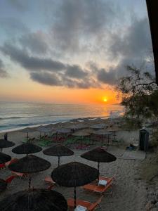 a group of umbrellas on a beach with the ocean at Oceanica k rooms in Loutsa
