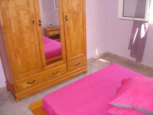 a bedroom with a mirror and a pink rug at villa les Grenadines in Entre-Deux