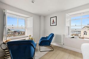 two blue chairs in a room with two windows at Pilgrim Suite - Sea View - Free Wi-Fi in Brixham