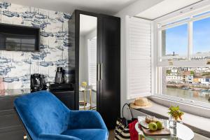 a living room with a blue chair and a table at Pilgrim Suite - Sea View - Free Wi-Fi in Brixham