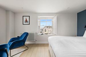 a bedroom with a bed and two blue chairs at Pilgrim Suite - Sea View - Free Wi-Fi in Brixham
