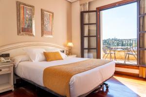 a bedroom with a large bed and a large window at Hotel Conde Ansúrez in Valladolid +79 photos