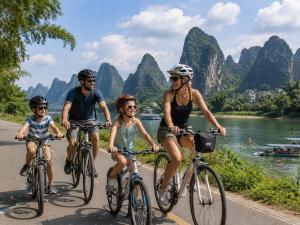 a family riding bikes down a road next to a river at Yangshuo Eden's Social Guesthouse - cozy garden courtyard & fresh craft coffee & night beers & outdoor activities in Yangshuo