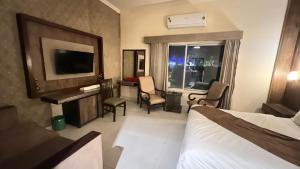 a hotel room with a bed and a television at Adams Lodge F-7 in Islamabad