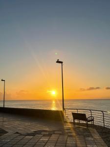 a bench on a pier with the sunset in the background at Hostjimeno Invierno in La Garita