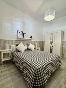 a bedroom with a large bed with a checkered blanket at Hostjimeno Invierno in La Garita