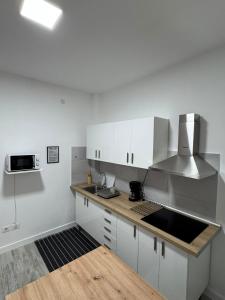 a kitchen with white cabinets and a counter top at Hostjimeno Invierno in La Garita