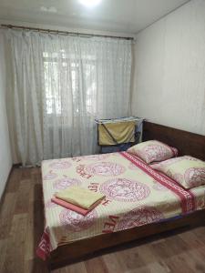 a bedroom with a bed with two pillows and a window at Letto UTZ in Mykolaiv