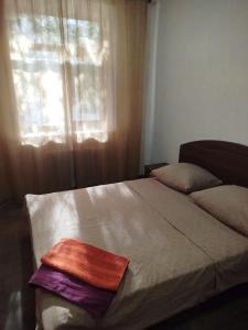 a bed with a towel on it in front of a window at Letto UTZ in Mykolaiv