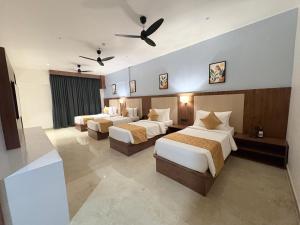 a hotel room with three beds and a ceiling fan at Omkar Jungle Resort & Spa, Sirsi in Islūr +36 photos