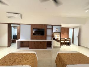 a living room with two beds and a television at Omkar Jungle Resort & Spa, Sirsi in Islūr