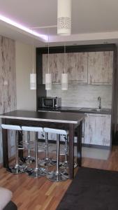 a kitchen with a large wooden table with bar stools at Apartments Vanja i Vrh in Kopaonik