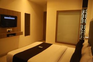 a room with a bed with a remote control on it at Hotel Abrol in Mumbai