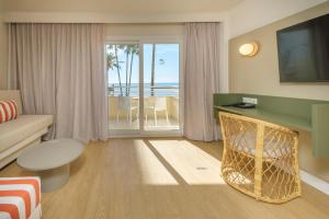 a living room with a couch and a table with a television at Cabot Cap de Mar Spa in Cala Bona