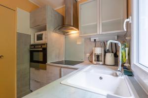 a kitchen with a sink and a microwave at Gîte Le Mazet Des Campanes in Saint Alban Auriolles +12 photos