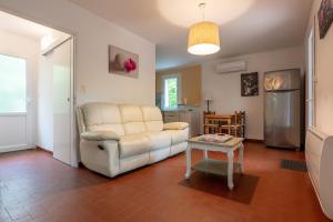 a living room with a couch and a table at Gîte Le Mazet Des Campanes in Saint Alban Auriolles