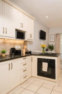 a kitchen with white cabinets and a black oven at The Prestige Studio in Bloemfontein