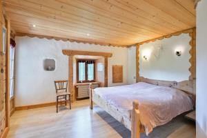 a bedroom with a bed and a wooden ceiling at La Ferme D'aurélie in Montvalezan